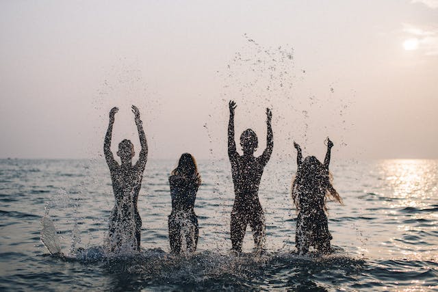 Four influencer friends posing for a Story in the sea.