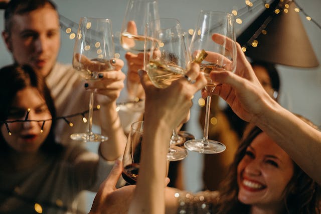 Um grupo de amigos a brindar às suas bebidas na véspera de Ano Novo.
