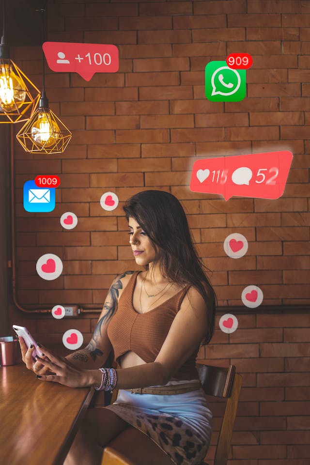 O femeie manager social își verifică telefonul și vede notificări de pe rețelele de socializare, cum ar fi Instagram like-uri și mesaje WhatsApp.