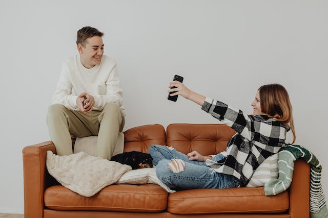 A teenage girl is showing her smartphone to a boy. 