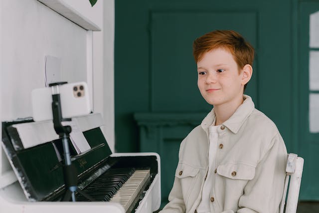 한 젊은 콘텐츠 크리에이터가 피아노를 연주하는 모습을 녹음합니다.
