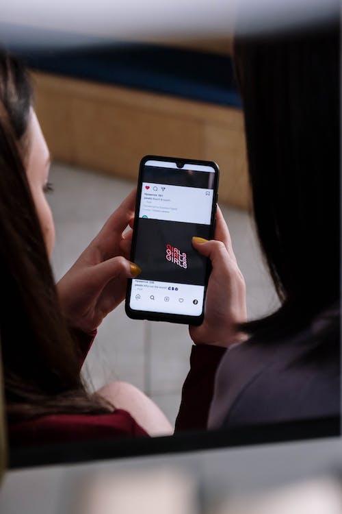 Des filles qui essaient de lire &quot;girls&quot; écrit sur un poteau Instagram . 