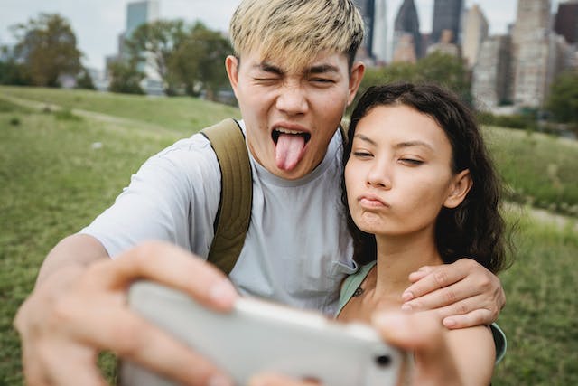 Een stel dat gekke, expressieve gezichten trekt terwijl ze een selfie nemen.