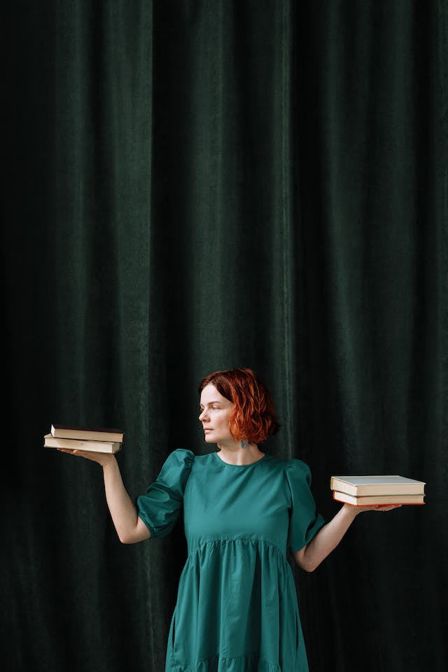  A woman deciding which among two sets of books to read.