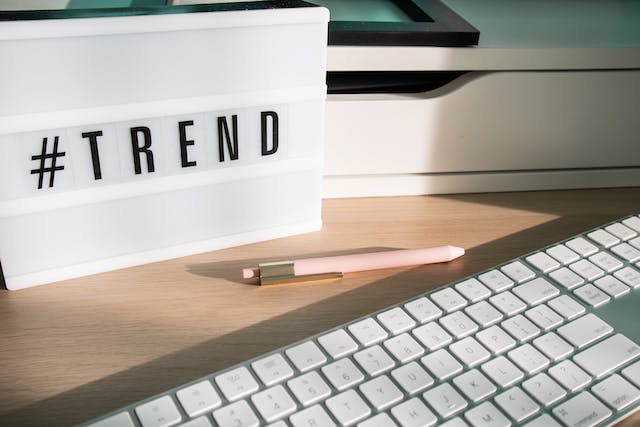 Un bureau avec un clavier et une boîte à lumière sur laquelle figure le hashtag #Trend.