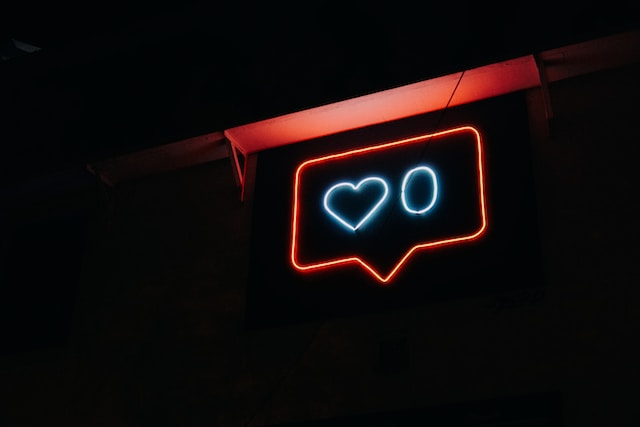 O imagine a unui semn de neon care ilustrează un emoji și un număr de like-uri Instagram .