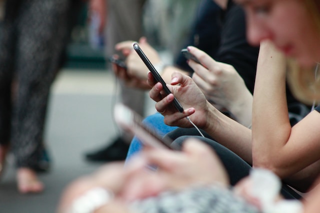 Een close shot van mensen die hun mobiele telefoon gebruiken en hun Instagram account controleren. 