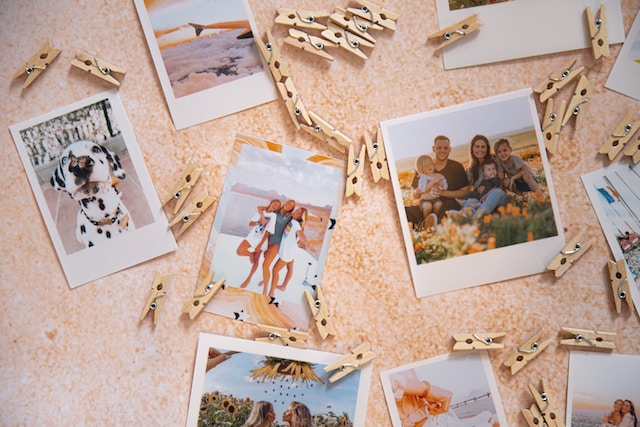  Photos of families, friends, and a pet dog scattered on a table along with many clips.