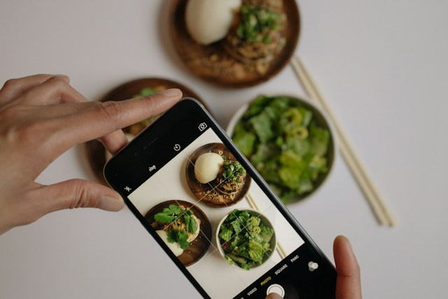 Uma pessoa que tira uma fotografia da sua comida para uma publicação em Instagram .