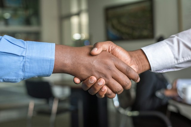 Two men are shaking hands with one another for a successful collaboration on Instagram. 