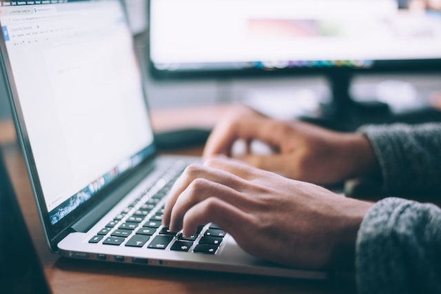 A person is typing on his computer, researching ways to increase his IG followers.