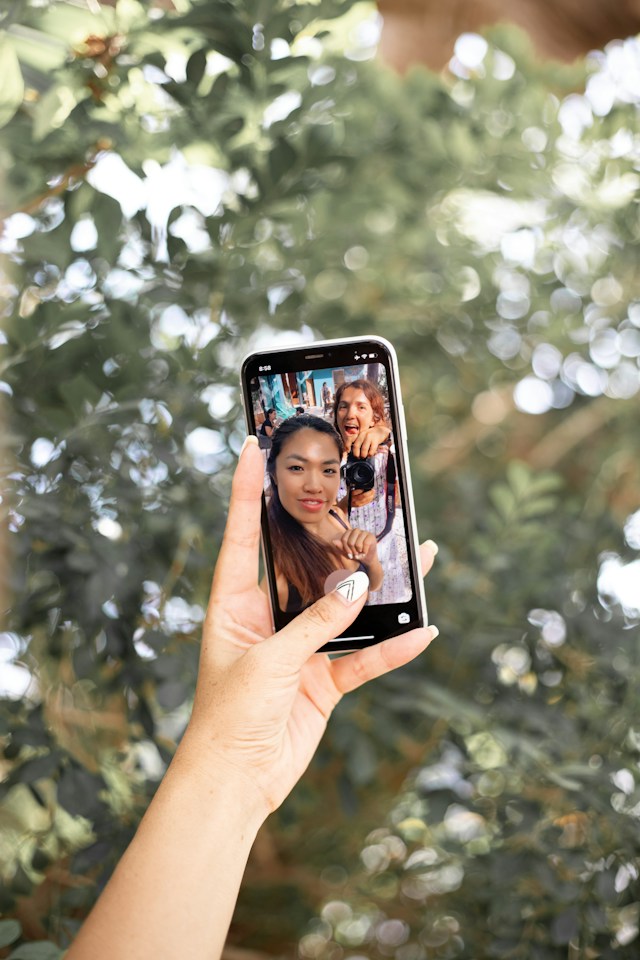 Duas mulheres estão a tirar uma selfie para publicar em Instagram.