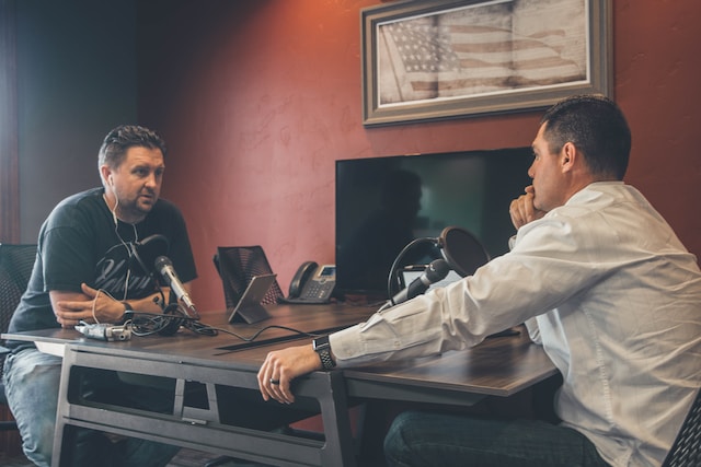 Two men engaged in a discussion for their podcast. 