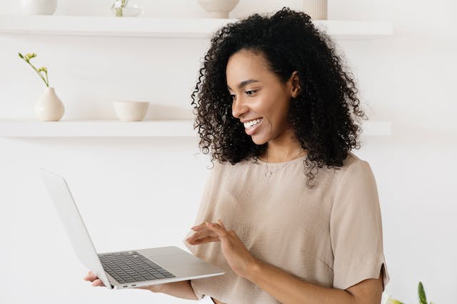 Eine Frau benutzt ihren Laptop, um Leuten auf Instagram zu folgen.