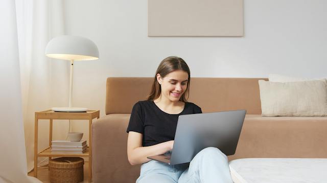 Una influencer donna sorride per vedere più commenti verificati sul suo post. 