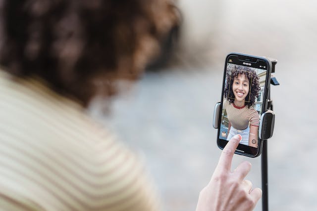 여성 콘텐츠 크리에이터가 Instagram 에 챌린지 영상을 촬영하기 위해 '녹화' 버튼을 클릭하고 있습니다.