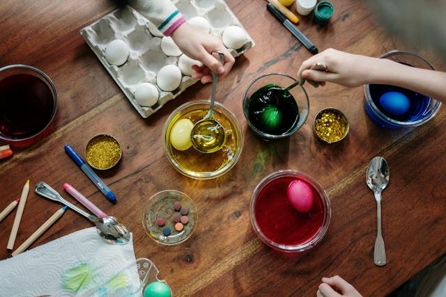 A flat-lay photo of kids coloring eggs for Easter.