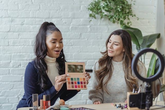 Two friends filming a makeup challenge together.