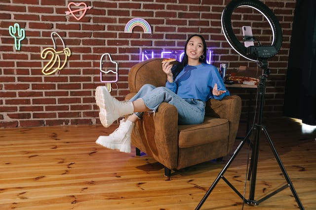 A female influencer filming herself talking to her loyal followers while eating pizza.