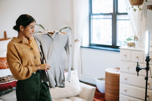 Une influenceuse qui filme une vidéo d'elle-même montrant les vêtements qu'elle a confectionnés en collaboration avec une marque.