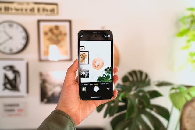 Alguien haciendo una foto estética de una decoración minimalista de pared con su iPhone.