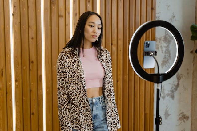 A female influencer filming in front of her camera with a serious face.