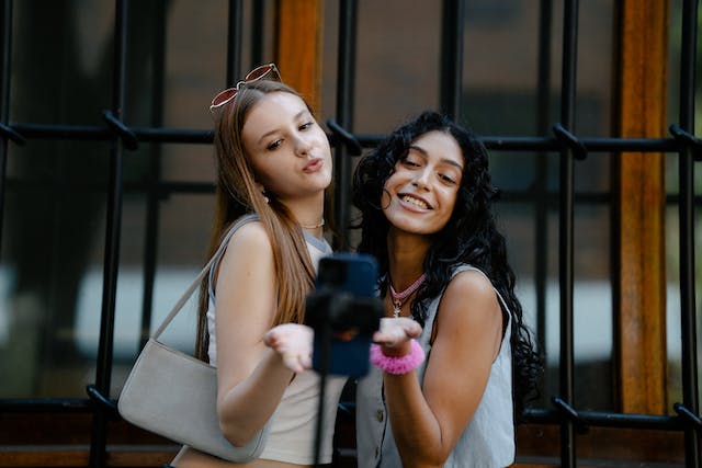 Two young female influencers filming a video for their Instagram collaboration.