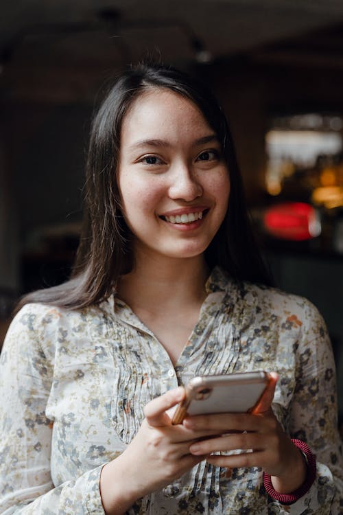 Een jong Aziatisch meisje is blij dat ze de Instagram gebruiker heeft gevonden die ze zocht. 