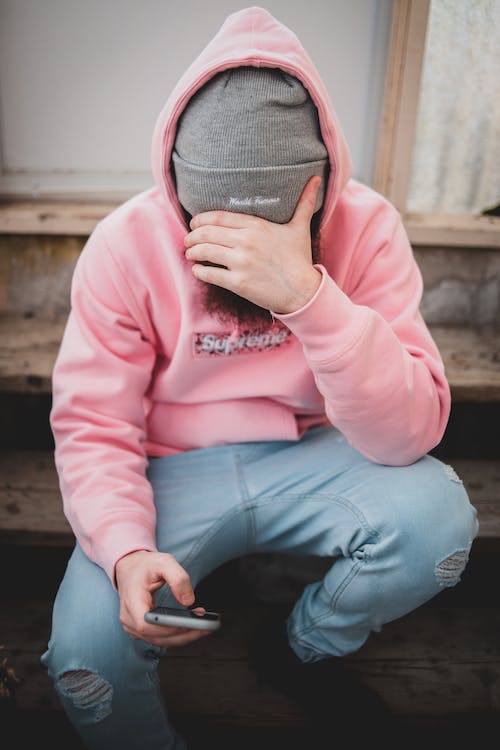 Der Mann mit der rosa Kapuze ist nicht in der Lage, einen Benutzer auf Instagram zu finden. 