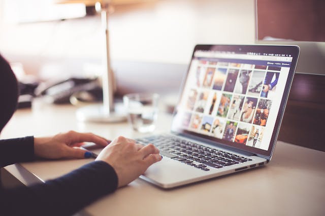 A woman viewing Instagram posts on a laptop.