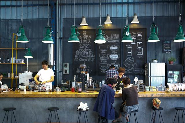 Un café de quartier avec quelques clients locaux à l'intérieur.