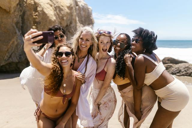 Un groupe de copines prenant un selfie à la plage pendant les vacances de printemps.