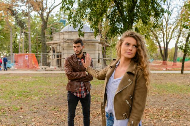 A couple having a lighthearted disagreement in a park.