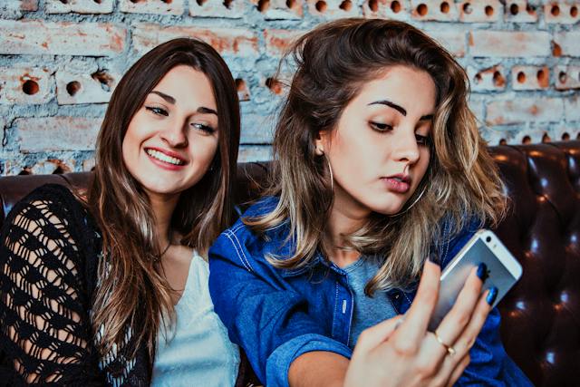 Zwei Influencerinnen posieren mit geschminkten Haaren und Make-up für ein glamouröses Selfie Instagram .