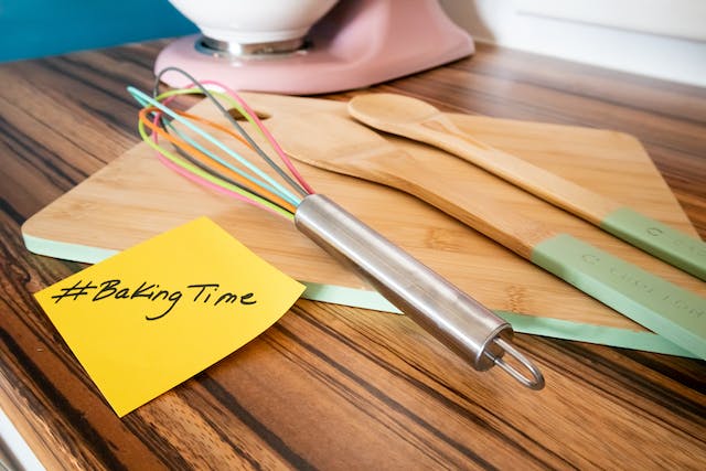 Backutensilien auf einem Küchentisch mit einem Klebezettel mit der Aufschrift #BakingTime.