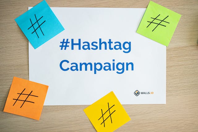 Ein Schreibtisch, auf dem ein Papier mit der Aufschrift #Hashtag Campaign liegt 