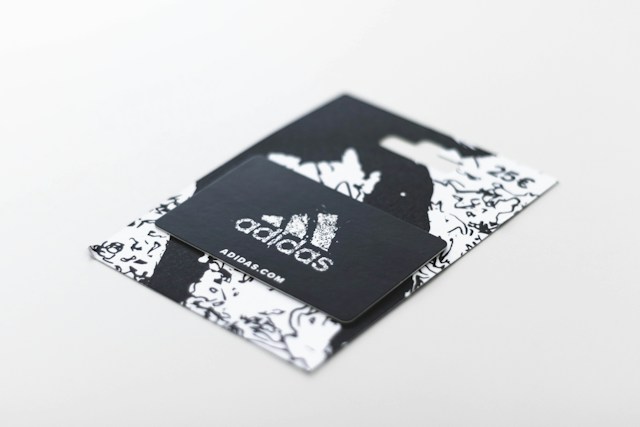 Un card cadou Adidas așezat pe o masă.