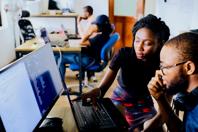 A man and a woman discussing something in front of the screen. 