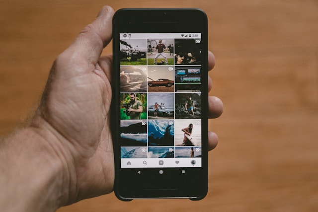 O persoană ține în mână un telefon Android negru cu Instagram Feed deschis. 