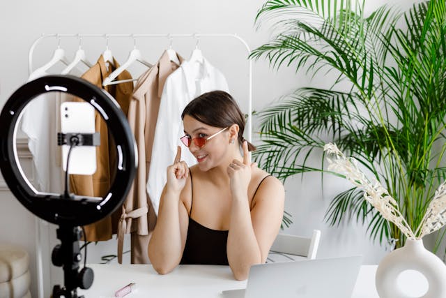 Een vrouw laat haar zonnebril zien terwijl ze een video opneemt met haar telefoon.