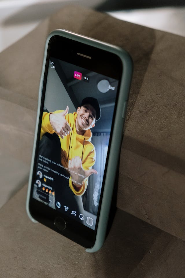  Der Bildschirm eines Telefons zeigt einen Mann, der eine Instagram Live.