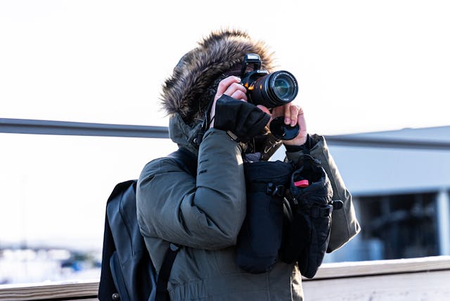 A person taking a picture with their Canon camera.