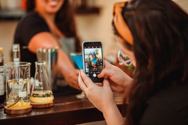 Une femme prenant une photo de sa boisson.