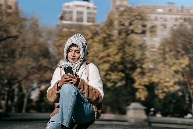 Una mujer usando su teléfono en el parque.