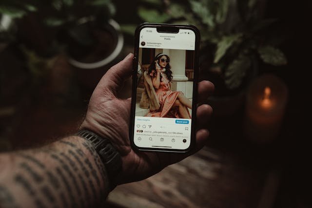 Qualcuno che tiene in mano un telefono con un post di Instagram con un pulsante "Boost post" visualizzato sullo schermo.