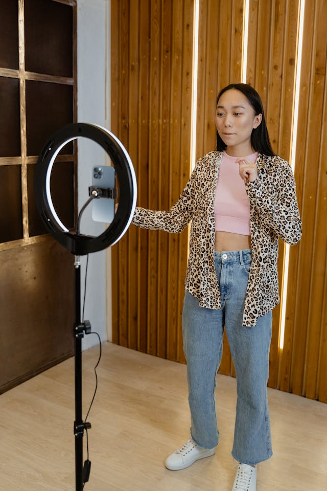 A woman doing a dance challenge while recording on her phone.