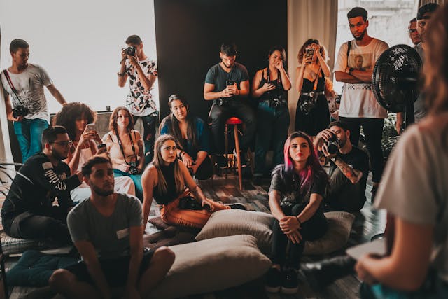 A group of young Millennials gathered to listen to someone speak.