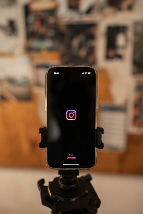 Ein auf einem Stativ montiertes Mobiltelefon mit der App Instagram auf dem Bildschirm