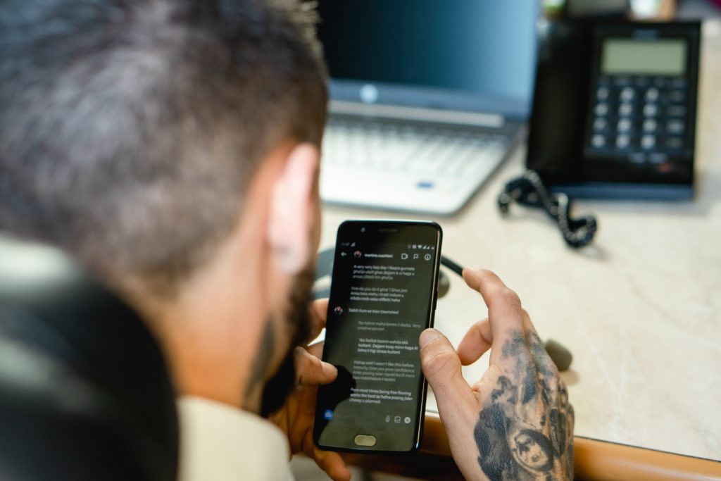 A person is chatting on Instagram on their phone in an office. 