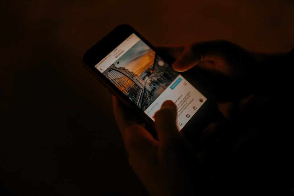Eine Person beobachtet im Dunkeln einen Beitrag auf Instagram .